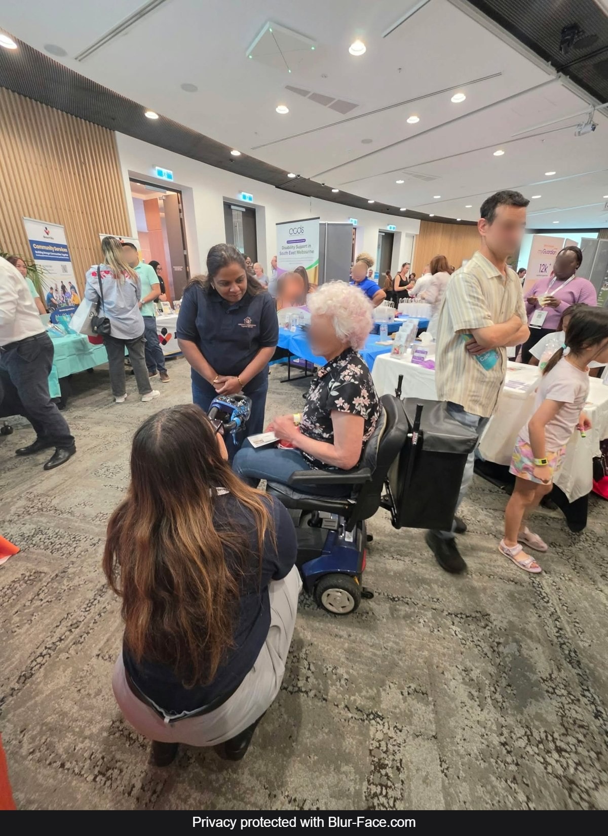 A Serenity Companions support worker chatting with an older visitor at the Melbourne NDIS Expo 2026