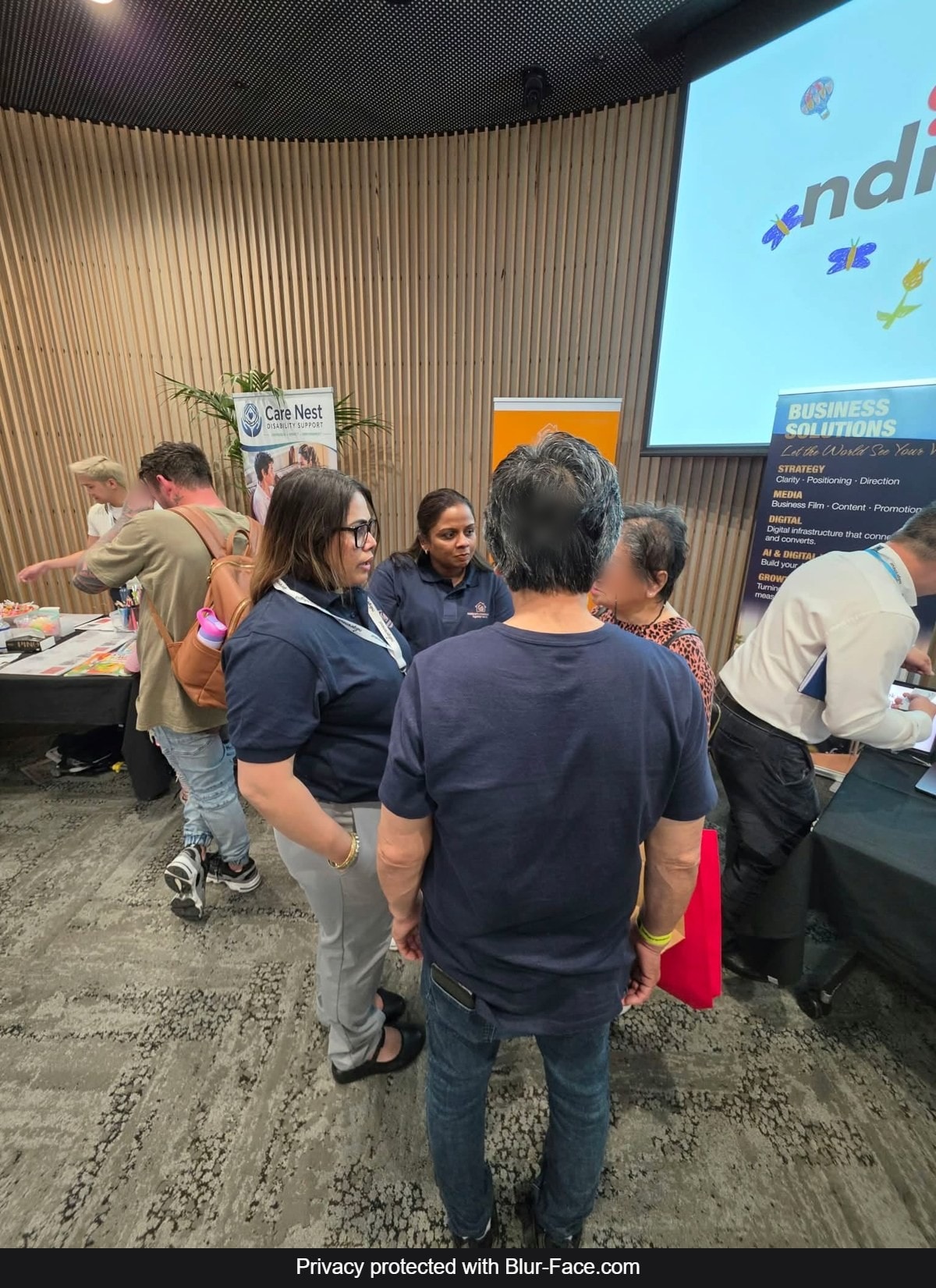 Our team answering questions about NDIS and Support at Home services at the expo